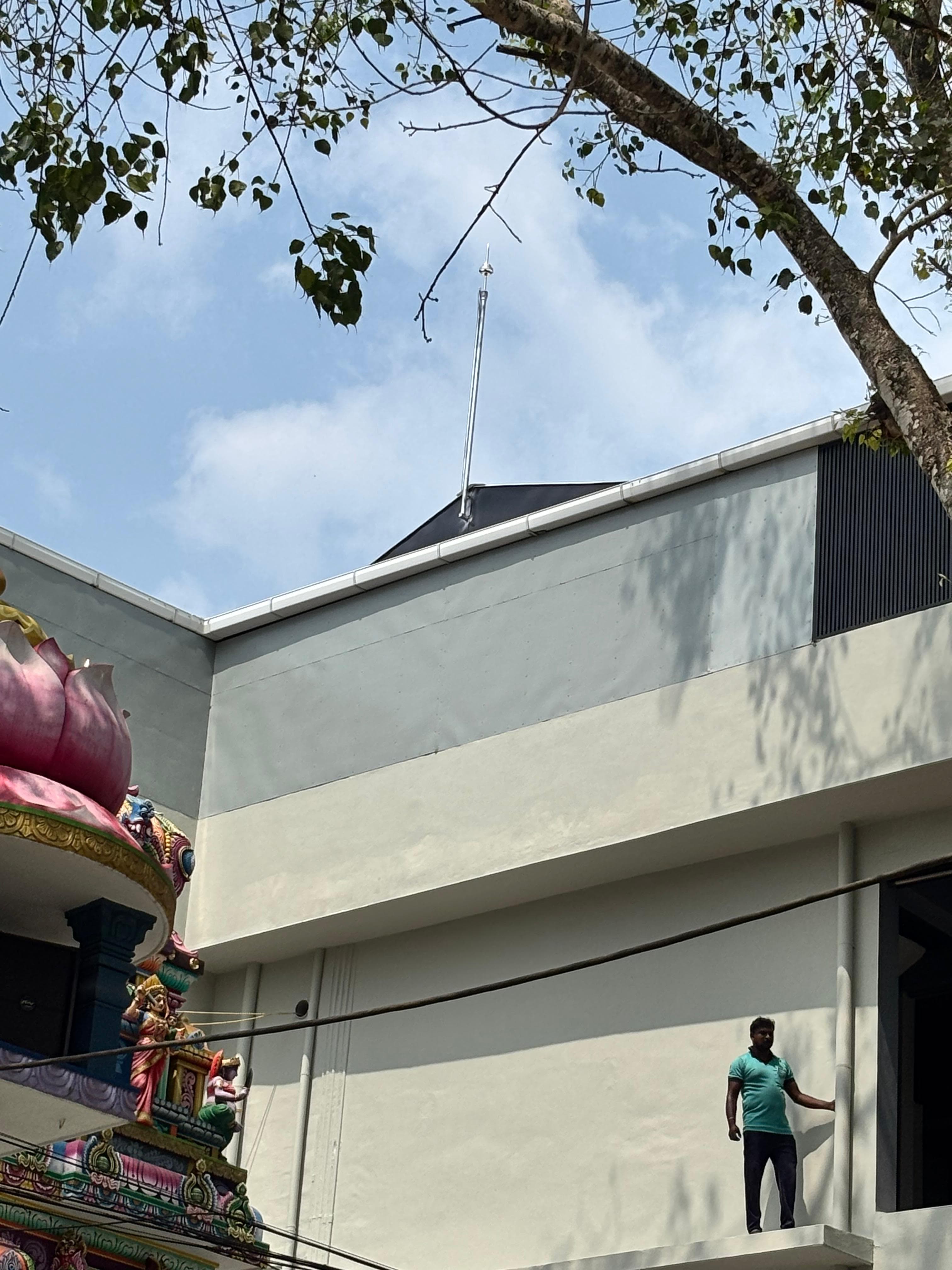 Lightning arrester installed on a rooftop mast above a temple building